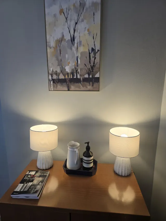 Softly lit detail of lamps, art, and a sideboard inside Eaton Gate Practice